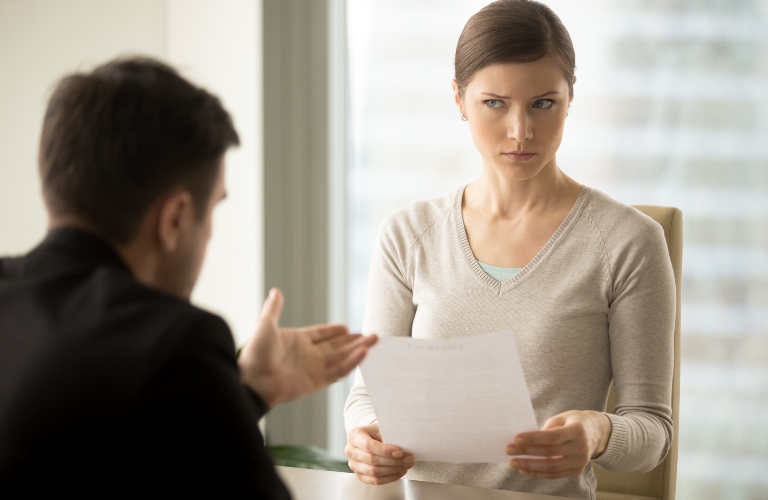 Woman looking suspiciously at a piece of paper