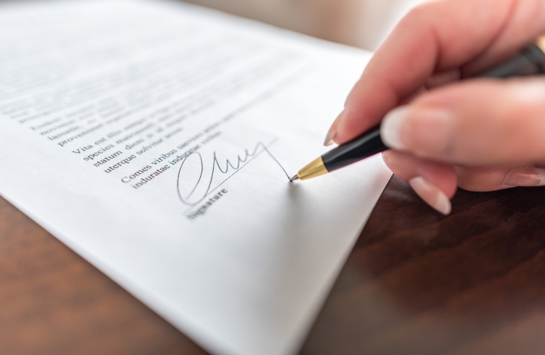 Woman signing a document with pen