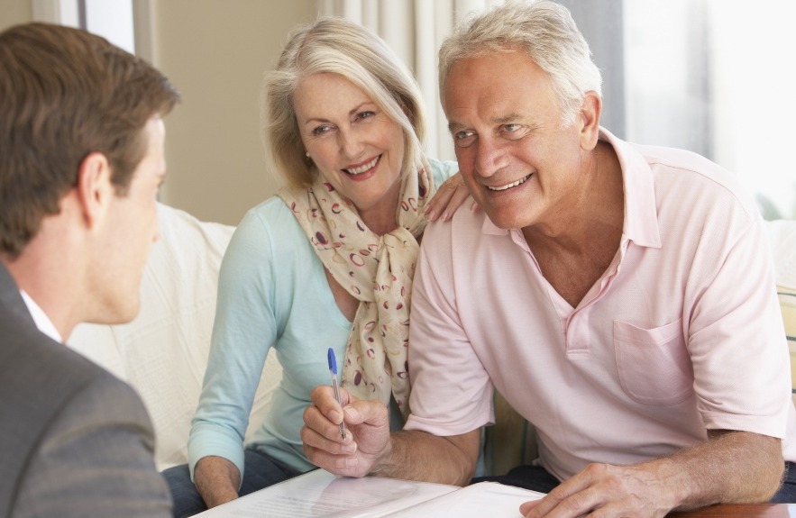 Old couple signing paperwork related to estate planning