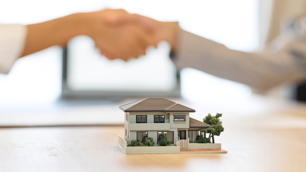 man and woman shaking hands and house model_s
