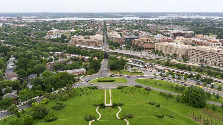 Aerial view of an urban area with green parks, roads, residential and commercial buildings.